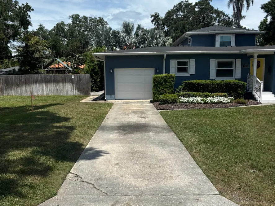 Before: stained concrete driveway at a blue Tampa home