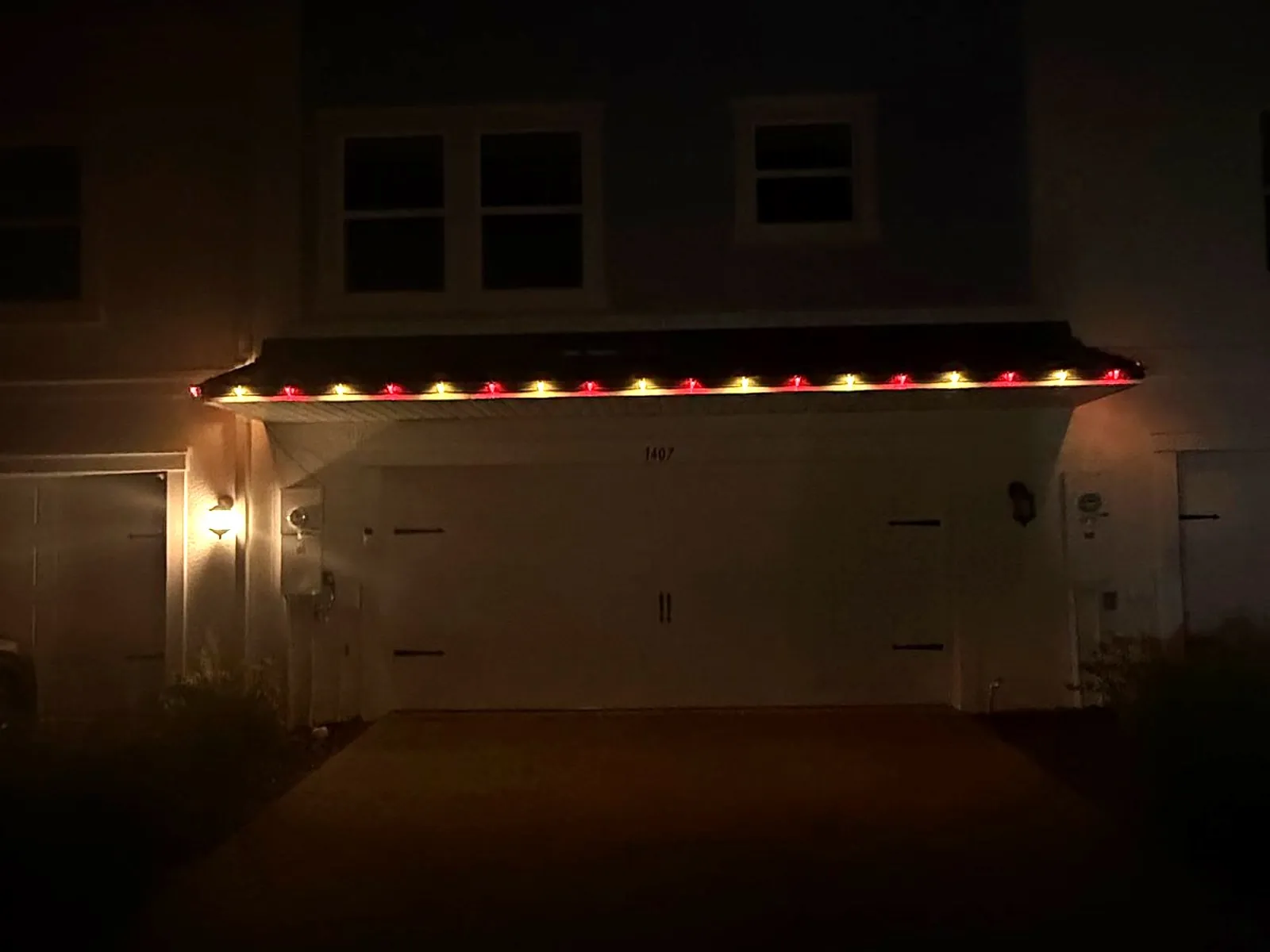 Close view of red and white C9 roofline Christmas lights above a Tampa garage