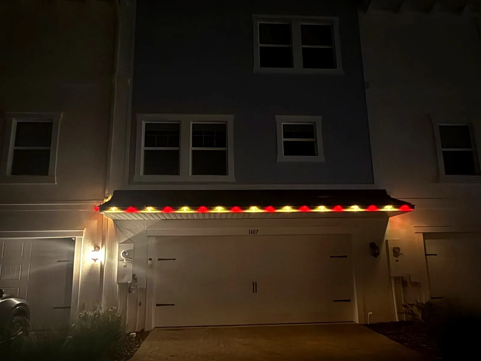 Red and warm white roofline Christmas lights installed on a Tampa home at night